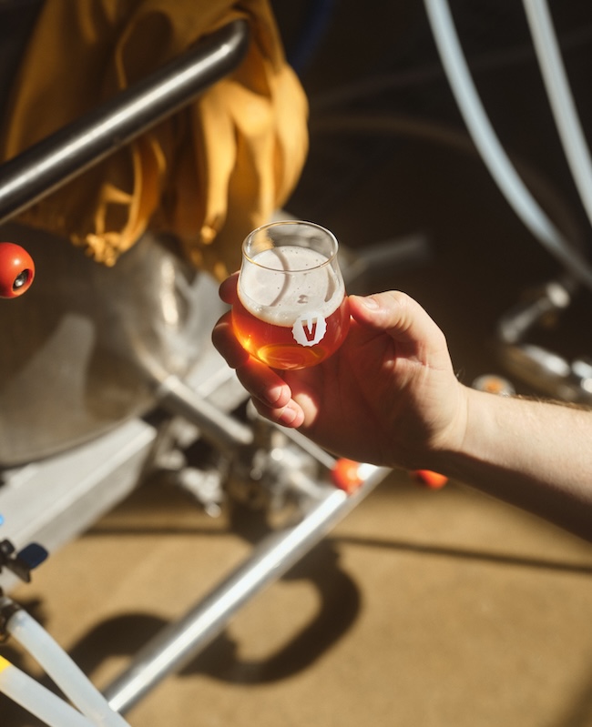 käsi ja lasissa tankista laskettua olutta